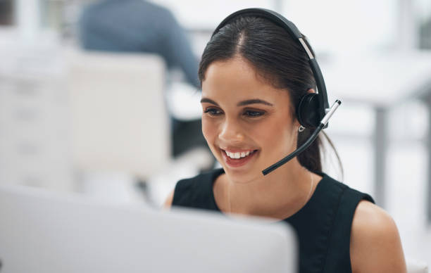 Happy woman, face and headphones in call center for customer service, telemarketing or support at office. Female person, consultant or agent smile with headset for online advice or help at workplace